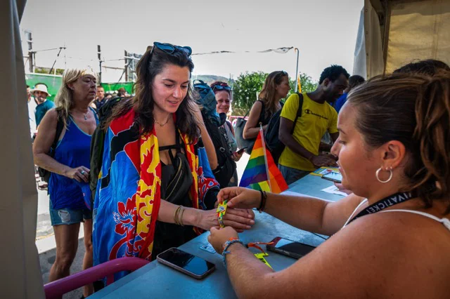 Público recogiendo su pulsera del festival. Firma_Luca Valenta en tamaño mediano