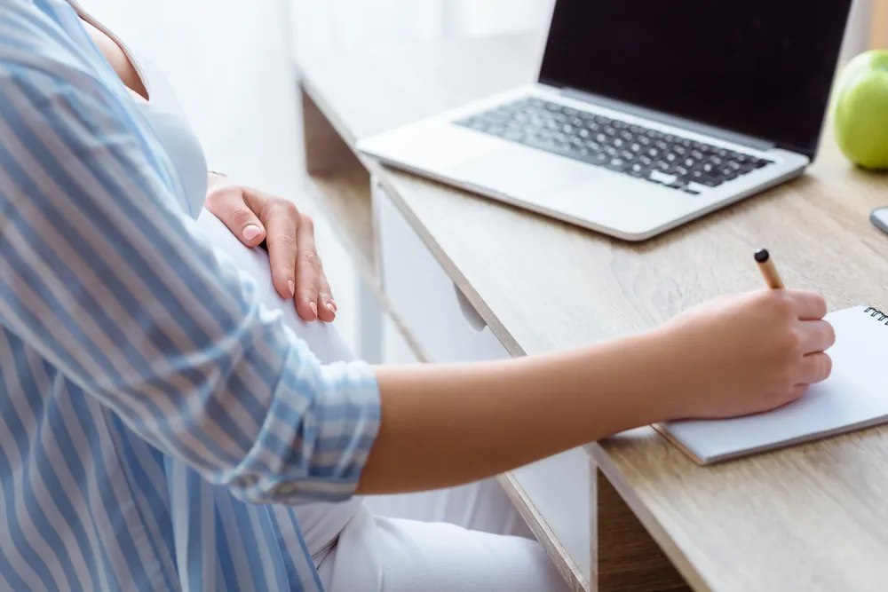cropped-view-of-pregnant-woman-writing-in-notepad-2024-11-18-22-51-08-utc