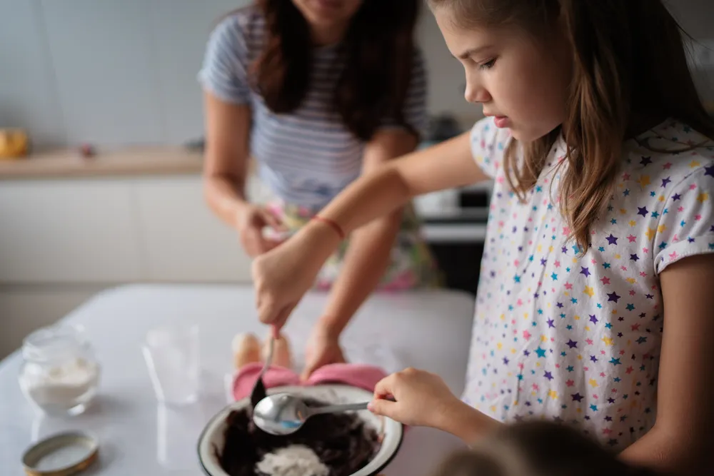 young-girl-learns-to-bake-with-family-in-kitchen-2024-10-20-00-39-44-utc