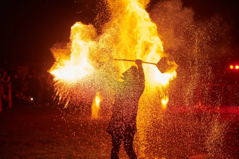silhouette-of-two-fire-performers-creating-sparks-2025-04-02-23-49-23-utc