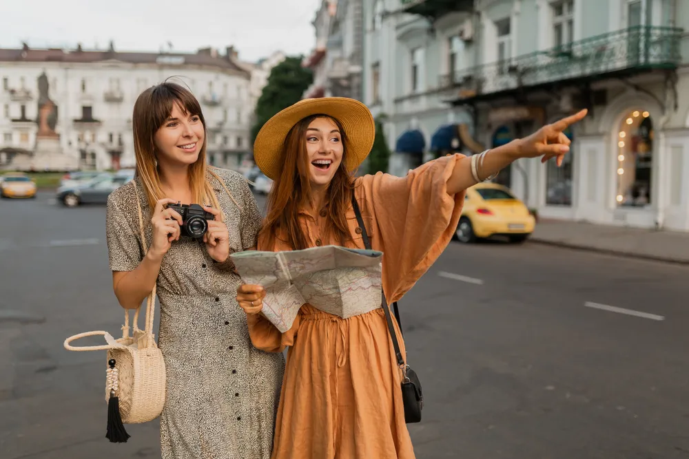 mujeres-jovenes-con-estilo-que-viajan-juntas-en-europa-vestidas-con-vestidos-y-accesorios-de-moda-de-primavera