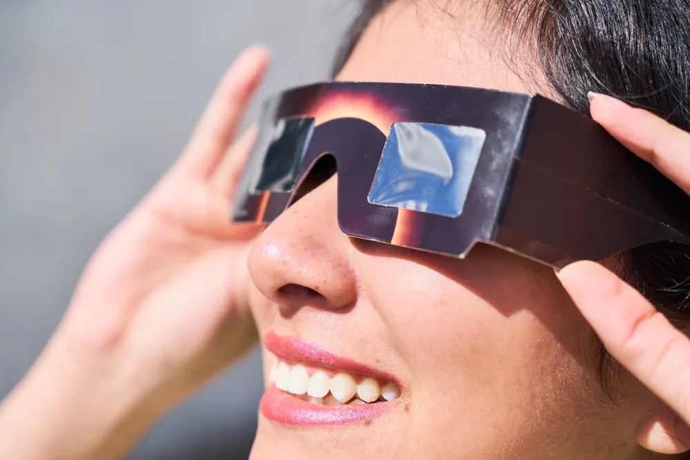 smiling-young-latin-woman-watching-an-eclipse-of-t-2024-12-04-14-43-24-utc
