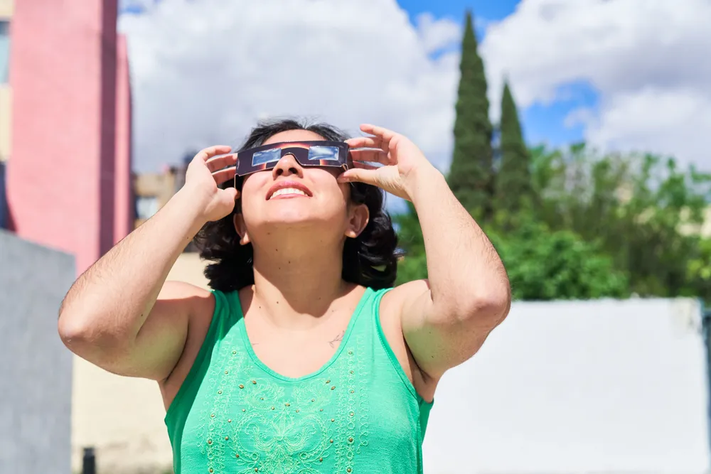 smiling-young-latin-woman-watching-an-eclipse-of-t-2024-12-05-12-23-07-utc